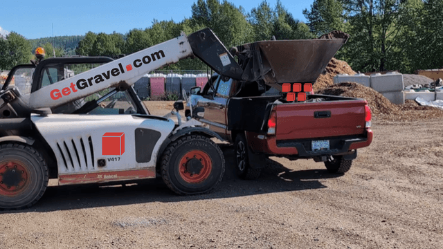 The bottom-opening bucket loading a pickup or trailer.